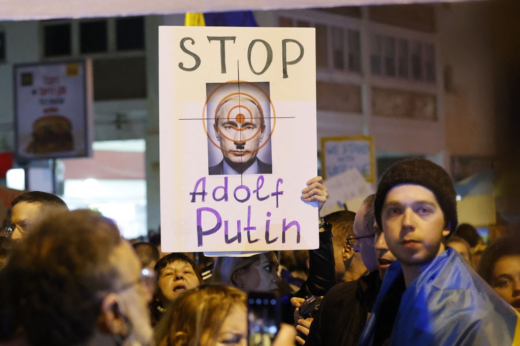 Демонстранты держат плакаты перед посольством России в Тель-Авиве, протестуя против вторжения. 