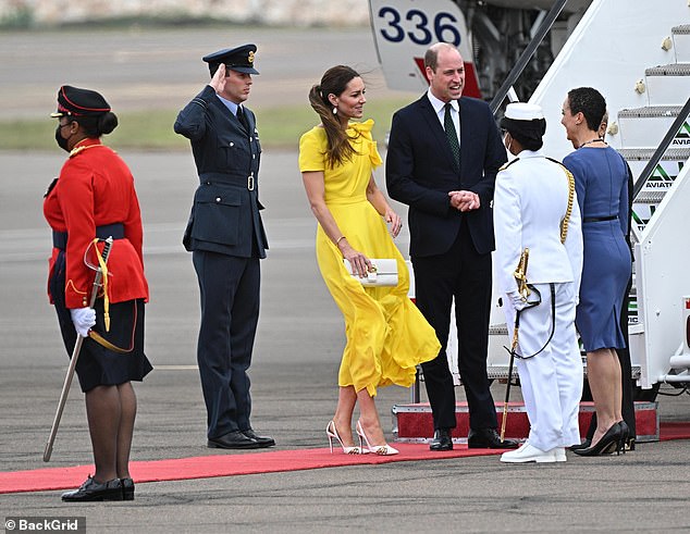 Кейт и Уильям приветствуют, когда они выходят из самолета по прибытии в международный аэропорт Нормана Мэнли в Кингстоне, Ямайка.