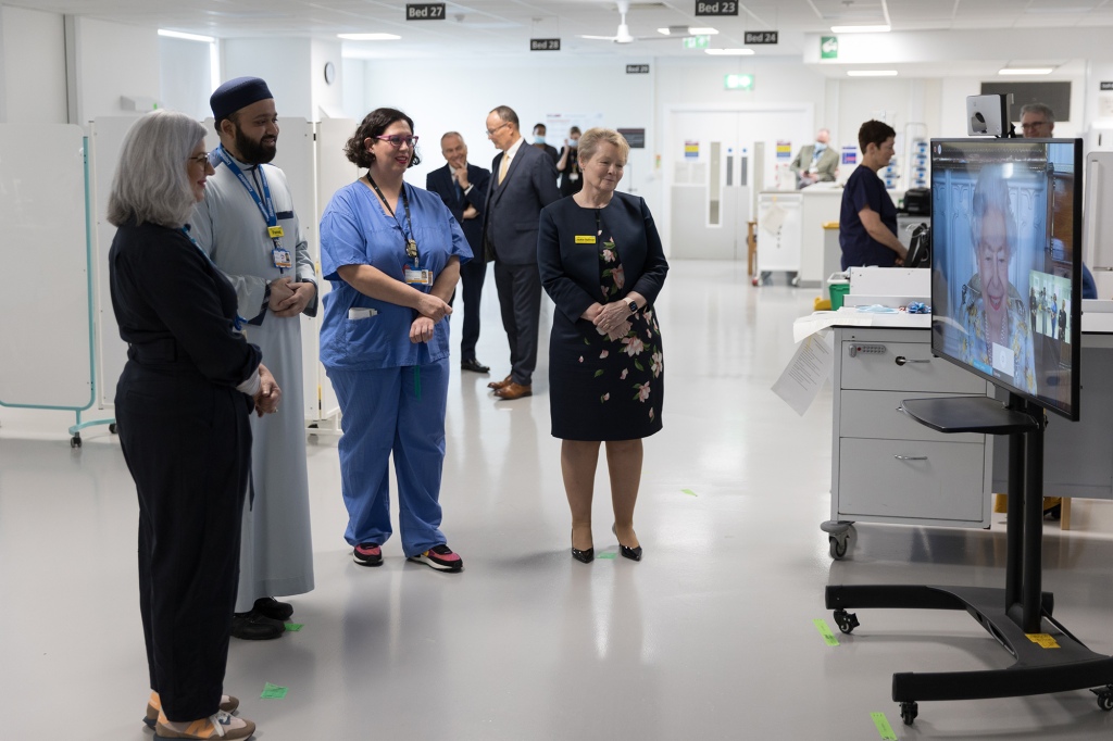Сотрудники NHS слушают королеву Елизавету во время видеозвонка, посвященного открытию отделения королевы Елизаветы в больнице.
