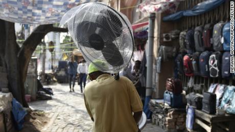 Мужчина держит веер во время жары в Калькутте, Индия.