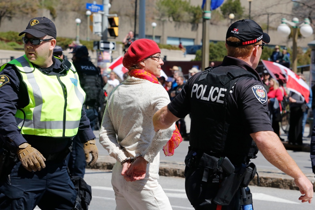 Полицейские задерживают человека, участвовавшего в демонстрации.