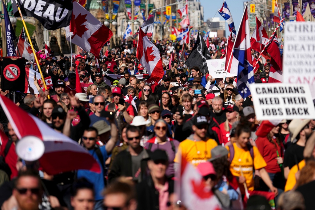 Демонстранты собирают и размахивают флагами во время демонстрации 30 апреля 2022 года.