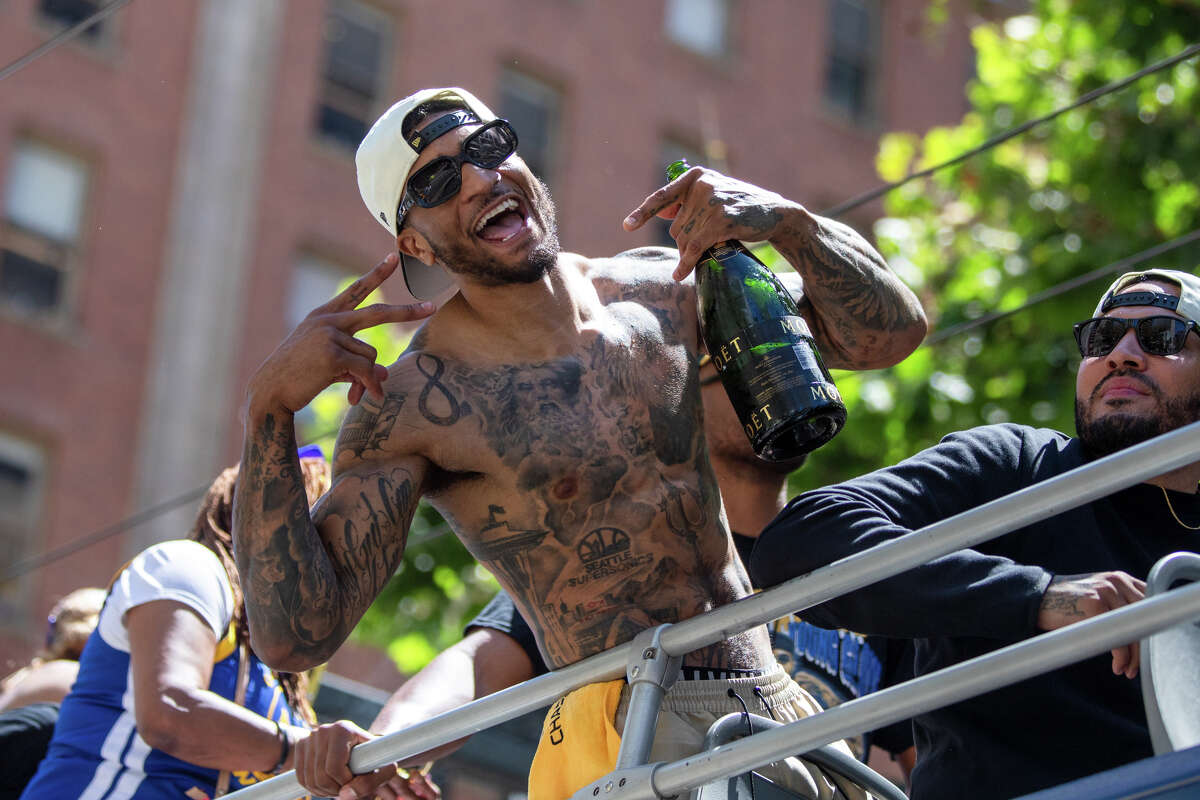 Форвард Гэри Пэйтон II позирует для фото с бутылкой шампанского Moet во время парада чемпионата Golden State Warriors на Маркет-стрит в Сан-Франциско, Калифорния, 20 июня 2022 года.