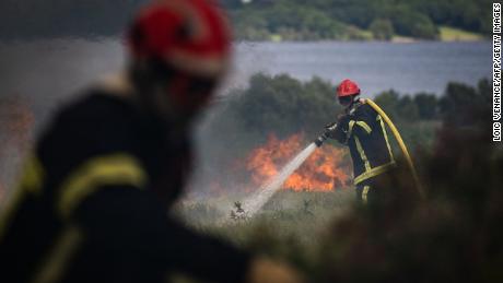 Пожарные поливают водой массивный пожар в Мон-д'Аре в Бретани, на северо-западе Франции.