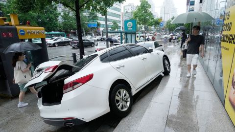 Автомобиль получил повреждения на тротуаре после сильного дождя в Сеуле, Южная Корея, 9 августа.